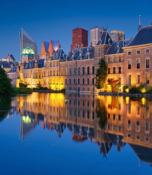 The Hague, Netherlands. A cityscape in the evening. View of historical buildings and modern business center. Reflections in the water. Architecture and design in the Netherlands.